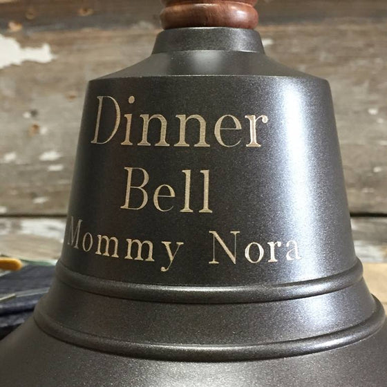 Closeup of three lines of engraving on a bronze finish brass 11 inch tall hand bell