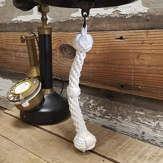 Closeup of white hand tied, braided bell pull rope with three knot design