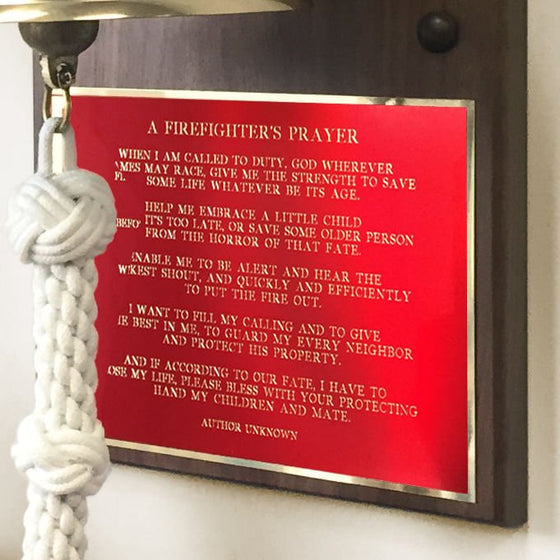 Closeup of A Firefighter's Prayer engraved in gold on a red metal plate