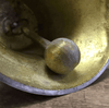 closeup of clapper on inside of hand bell