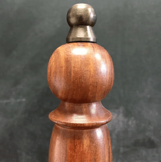 Closeup of antiqued brass finial on top of 9 inch hand bell