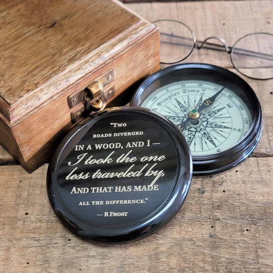 Three inch diameter antiqued brass compass with Robert Frost poem engraved on the cover with a wood display box