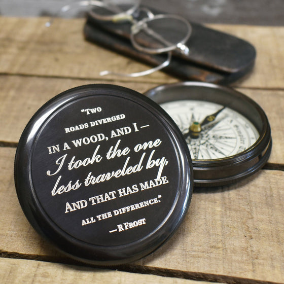 closeup of 3 inch diameter antiqued brass compass lid with Robert Frost Poem about two roads diverging