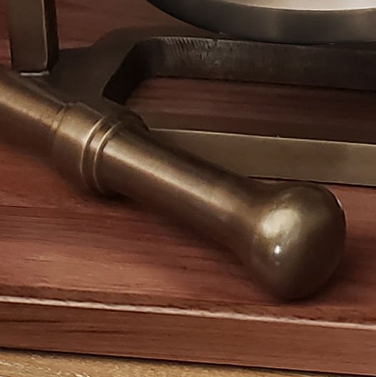Closeup of solid brass striker for an antiqued brass desk bell