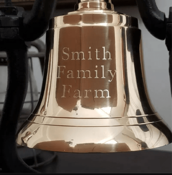 Closeup of three lines of optional text engraving on polished brass railroad bell
