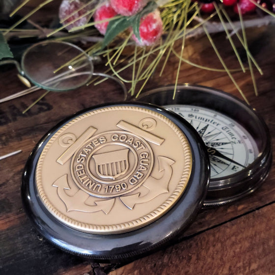 Coast Guard pewter medallion mounted on top lid of 3 inch diameter antiqued brass working compass