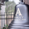 10 inch diameter solid brass wall bell in bronze finish engraved with large letter "A" over family name Abbott and established date