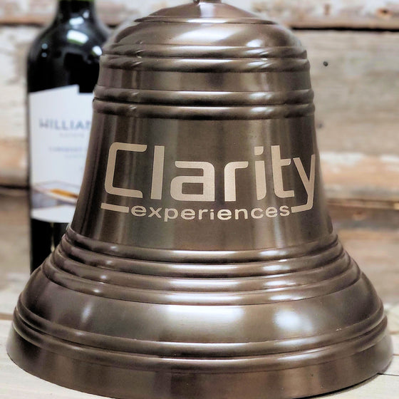 12 inch antiqued brass ridged bell shown with example of logo engraving for Clarity Experiences