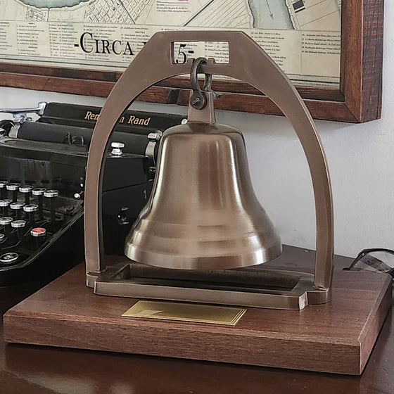 Antiqued brass bell with arch mounted on deluxe walnut base 