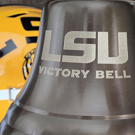 LSU Victory Bell with a yellow football helmet in the background