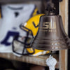 LSU Victory Bell with sports equipment in the background