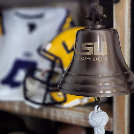 LSU Victory Bell with sports equipment in the background