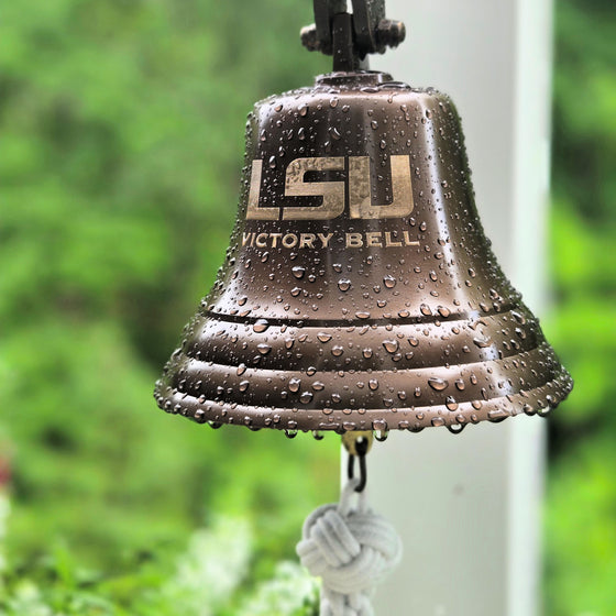 LSU Victory Bell with water droplets against a blurred green background