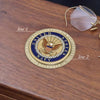 United States Navy emblem on a wooden surface with glasses in the background