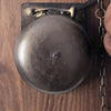 Replica distressed finish brass boxing bell on wood plaque with boxing gloves hanging nearby