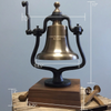 A brass railroad bell with a wooden base displayed on a table, with overlaid dimension lines and labels showing measurements such as 17 inches, 12 inches, 8.5 inches, 3 inches, and 9.