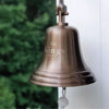 Closeup of hanging 10 inch antiqued brass bell with 3 lines of engraving showing The Kings, est. 1993.