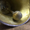 Closeup of larger clapper hitting edge of brass bell on an 11 inch tall hand bell