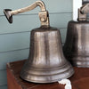 12 inch distressed finish antiqued brass wall bell shown displayed with mounting arm on wood box