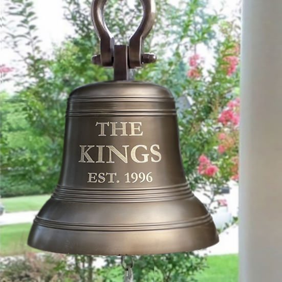 14" ridged antiqued finish bell with shackle attachment hanging outside with three lines of engraving