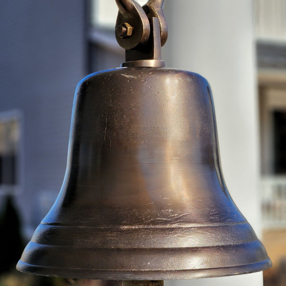 Closeup of the antiqued, distressed finish on a 14 inch distressed solid brass bell with shackle attachment