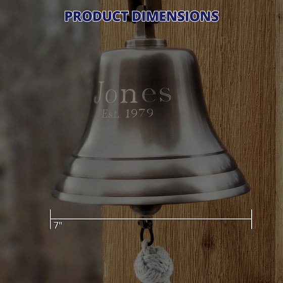 Closeup of engraved antiqued finish solid brass wall bell showing dimensions of bell as 7 inches wide