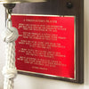 Closeup of A Firefighter's Prayer engraved in gold on a red metal plate