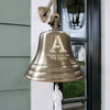 8 inch diameter antiqued brass finish Family Initial Bell with letter A above lines "Welcome to our Home" and "THE AKERS" mounted on wall outside front door of house