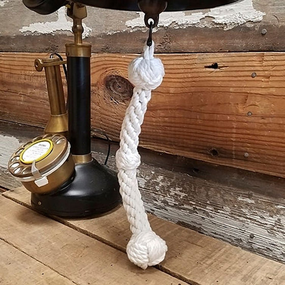 Closeup of hand braided white cotton bell pull rope with three knot design