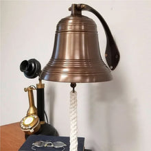  8 inch diameter antiqued finish solid brass ridged wall bell with antique candlestick phone and glasses for size perspective