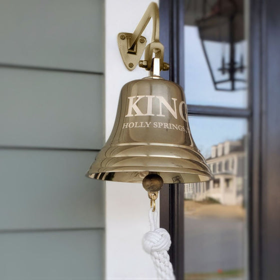 8 inch polished finish solid brass wall bell with two lines of custom engraving mounted near front door outside