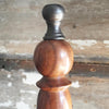 Closeup of brass finial on top of wood hand bell handle