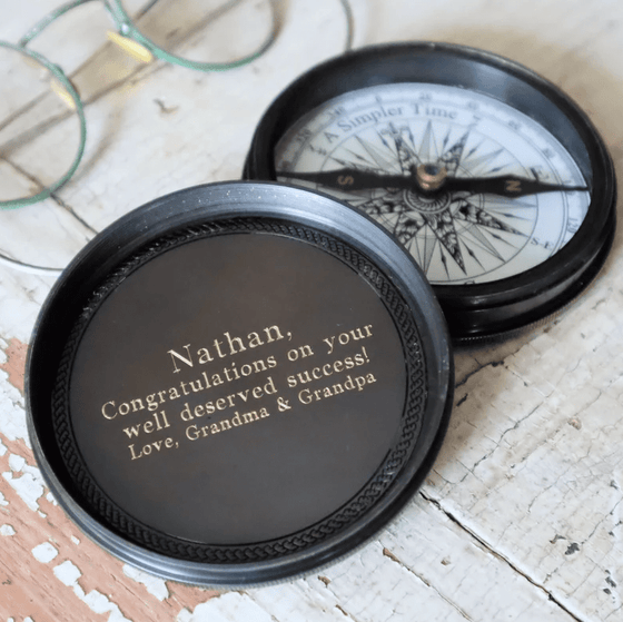 Example of four lines custom text engraving on inside top lid of three inch antiqued brass compass
