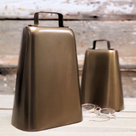 Extra large 8. 5 inch tall antiqued finish solid brass cow bell shown with glasses and large cowbell for size reference