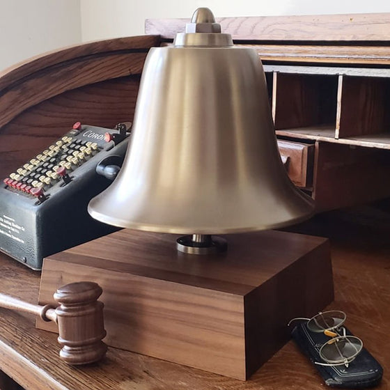 Large antiqued brass stock market bell mounted on a deluxe 3 inch tall walnut wood base with mallet, vintage glasses and antique adding machine