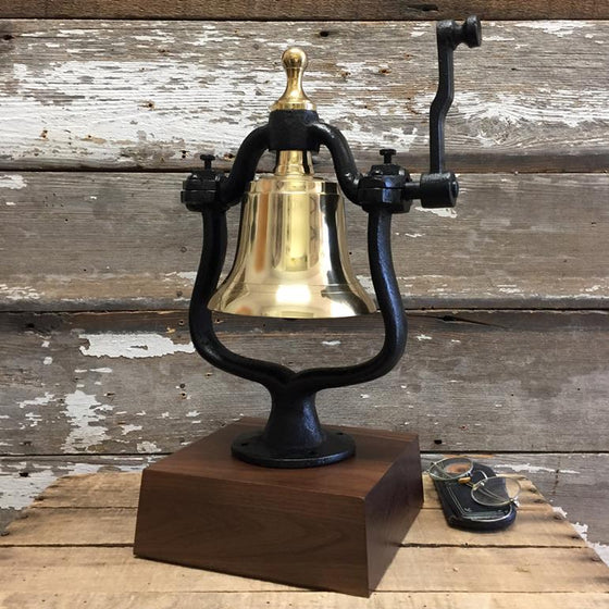 Medium polished finish solid brass railroad bell with cast iron mount on a three inch tall walnut deluxe base