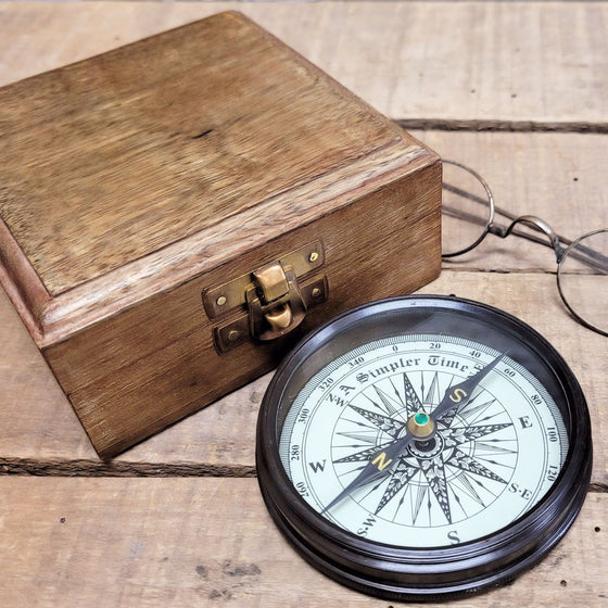 Hardwood and brass display box and open compass showing jeweled dial