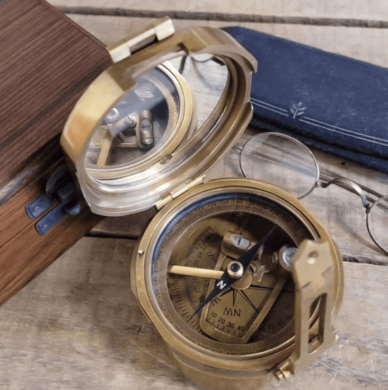 Closeup of an open  3 inch diameter antiqued brass military compass replica showing mirror and compass face